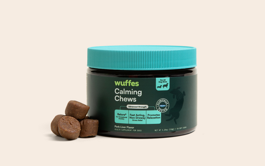 Container of Wuffes Calming Chews with four brown chew pieces beside it on a light background