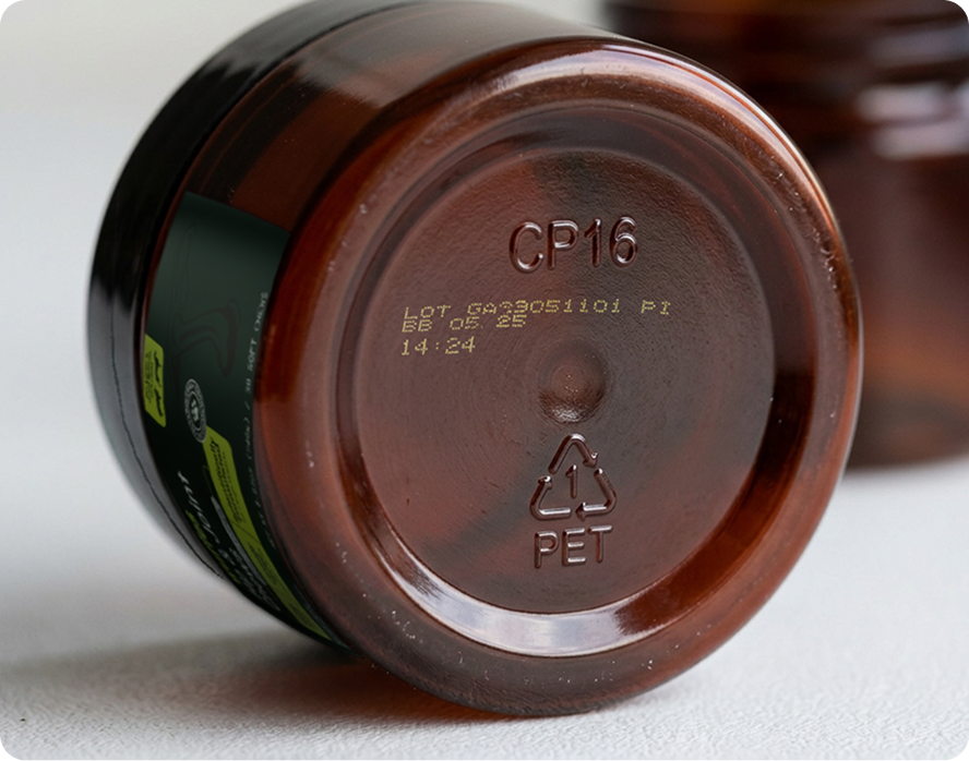 Close-up of a brown plastic container bottom with batch code and recycling symbol visible