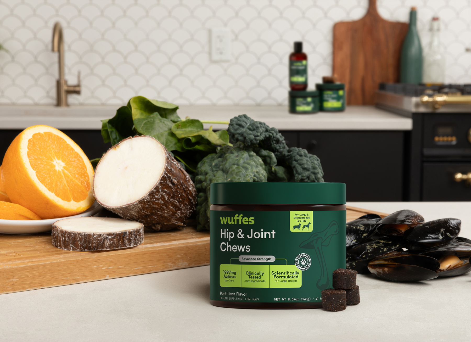 Dog hip and joint chews container surrounded by fresh vegetables and fruits on kitchen counter.